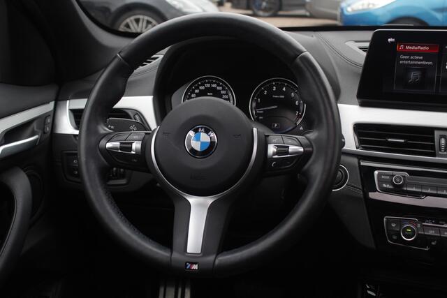BMW X1 sDrive18i High Exe. M Sport / Trekhaak / Half leder / Navi. Proff / Parkeerhulp V+a / 18'' / Stoelverwarming / DAB / Cruise Control