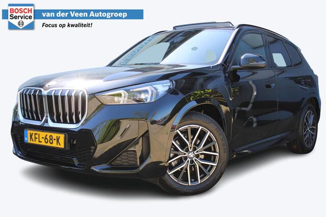 BMW X1 sDrive18i M-Sport | Panorama dak | Elektrisch wegklapbare trekhaak | Stoelverwarming | Achteruitrijcamera | Elektrische kofferbakklep | Keyless entry/start | Half leder/alcantara | Draadloze telefoonlader | Apple CarPlay/Android Auto | Navigatie | Climate controle | Parkeersensoren V+A |