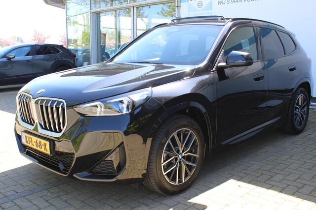 BMW X1 sDrive18i M-Sport | Panorama dak | Elektrisch wegklapbare trekhaak | Stoelverwarming | Achteruitrijcamera | Elektrische kofferbakklep | Keyless entry/start | Half leder/alcantara | Draadloze telefoonlader | Apple CarPlay/Android Auto | Navigatie | Climate controle | Parkeersensoren V+A |