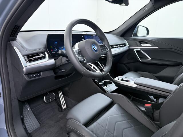 BMW iX1 eDrive20 67kWh M Sport pakket Pano-Dak/Schuif-dak Leer SOH 100% Warmtepomp Camera Navi Ecc PDC-a+v Apple Carplay Android Auto Elek.Achterklep Zwarte-Hemel VerkeersbordHerkenning WiFi M Aerodynamica Lmv Led Privacy Glas Isofix DAB Keyless Wifi 1e Eigenaar