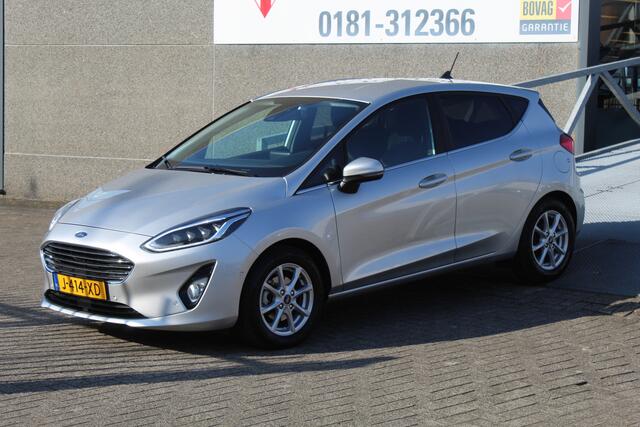 Ford FIESTA 1.0 EcoBoost Titanium Navigatie/Adaptive cruise control/Climate control/Lane assist/Apple carplay/Stoelverwarming/Stuurverwarming/Voorruitverwarming/Achteruitrijcamera/Parkeersensoren rondom/Dodehoek detectie/Keyless/Bluetooth/Lichtmetalen velgen.