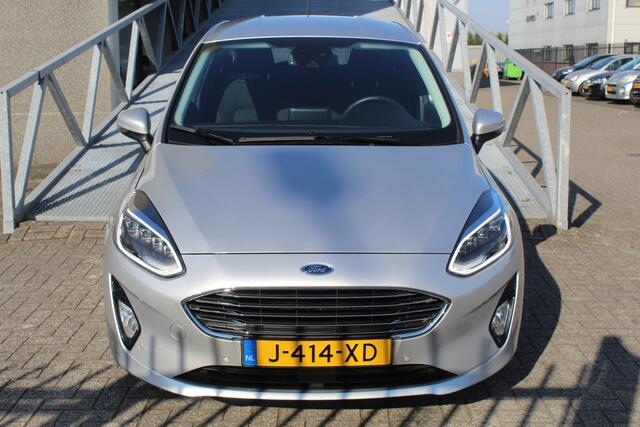 Ford FIESTA 1.0 EcoBoost Titanium Navigatie/Adaptive cruise control/Climate control/Lane assist/Apple carplay/Stoelverwarming/Stuurverwarming/Voorruitverwarming/Achteruitrijcamera/Parkeersensoren rondom/Dodehoek detectie/Keyless/Bluetooth/Lichtmetalen velgen.
