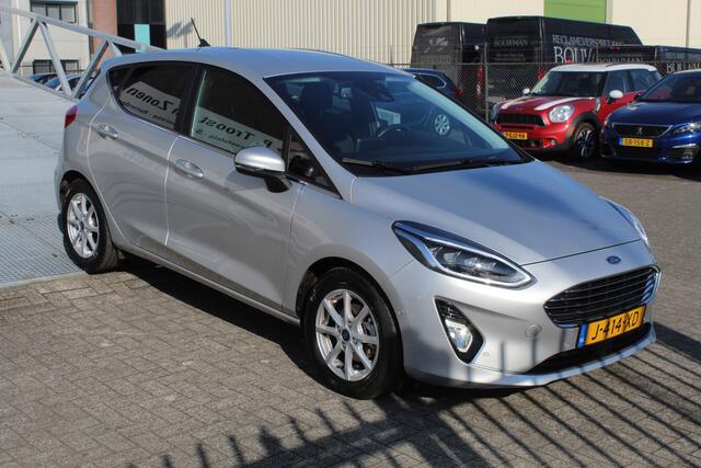 Ford FIESTA 1.0 EcoBoost Titanium Navigatie/Adaptive cruise control/Climate control/Lane assist/Apple carplay/Stoelverwarming/Stuurverwarming/Voorruitverwarming/Achteruitrijcamera/Parkeersensoren rondom/Dodehoek detectie/Keyless/Bluetooth/Lichtmetalen velgen.