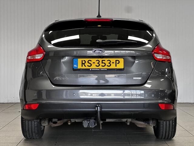 Ford FOCUS 1.0 Titanium/ Trekhaak/ 16'' LMV/ Camera/ Extra getint glas/ Apple + Android/ Navi/ Clima/ Cruise/ Elek. pakket/ Bluetooth/ Armsteun/ Multi. LEDER. Stuur/ Mistl./ PDC V+A.
