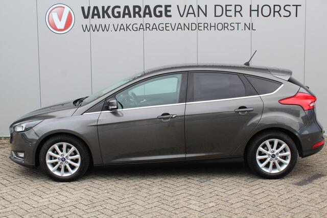 Ford FOCUS 1.0-125pk Titanium. Erg nette en luxe Ford Focus. Stoel-, stuur- en voorraamverw., autm. airco dual, navigatie, metallic lak, telefoonvoorb., camera, pdc v+a, dodehoek assist, AllSeason banden rondom, trekhaak, LM wielen etc.