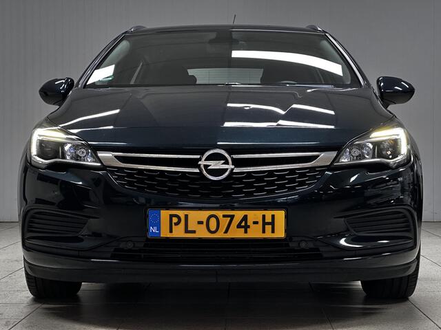 Opel ASTRA Sports Tourer 1.0 Online Edition/ Trekhaak/ Apple + Android/ DAB+/ Navi/ Airco/ Cruise/ Elek. pakket/ Isofix/ Bluetooth/ Armsteun/ Multi. LEDER. Stuur/ PDC V+a/ Dakrails/ LED Dagrijverl.