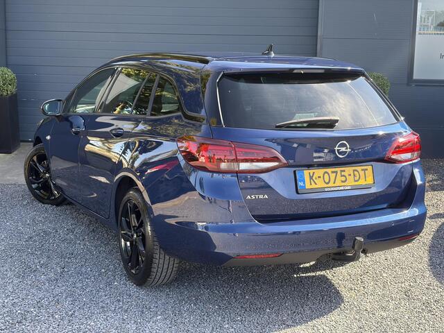 Opel ASTRA Sports Tourer 1.2 Ultimate 2e Eigenaar l Trekhaak l Camera l Carplay l Navi l Alcantara-Leder l 17''Lmv l Stoelverw-Stuurverw l Net beurt gehad l Dodehoek l Rijstrooksensor l Pdc V+A l 6 Bak l N.A.P l 146pk l Bj 11-2020 l Apk tot 08-2028